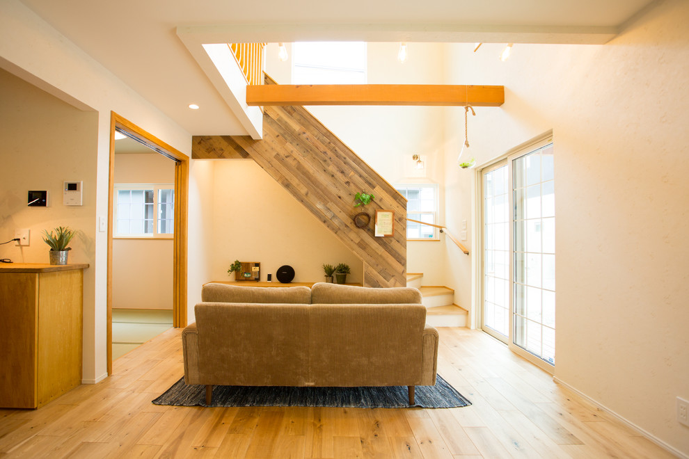 Mittelgroßes, Offenes Stilmix Wohnzimmer mit weißer Wandfarbe, braunem Holzboden und braunem Boden in Sonstige