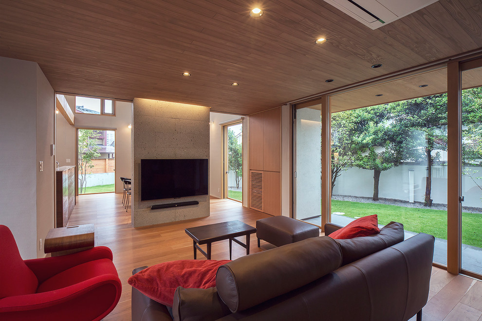 Idee per un soggiorno etnico con pareti bianche, pavimento in legno massello medio, TV a parete e pavimento marrone