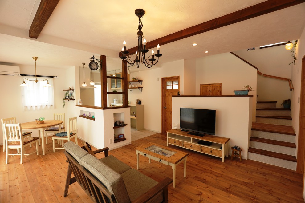 Cette image montre un petit salon rustique ouvert avec un mur blanc, un sol en bois brun, un téléviseur indépendant et un sol marron.