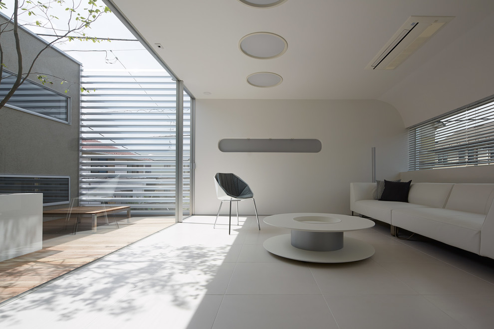 На фото: гостиная комната в современном стиле с белыми стенами и полом из керамической плитки без камина, телевизора