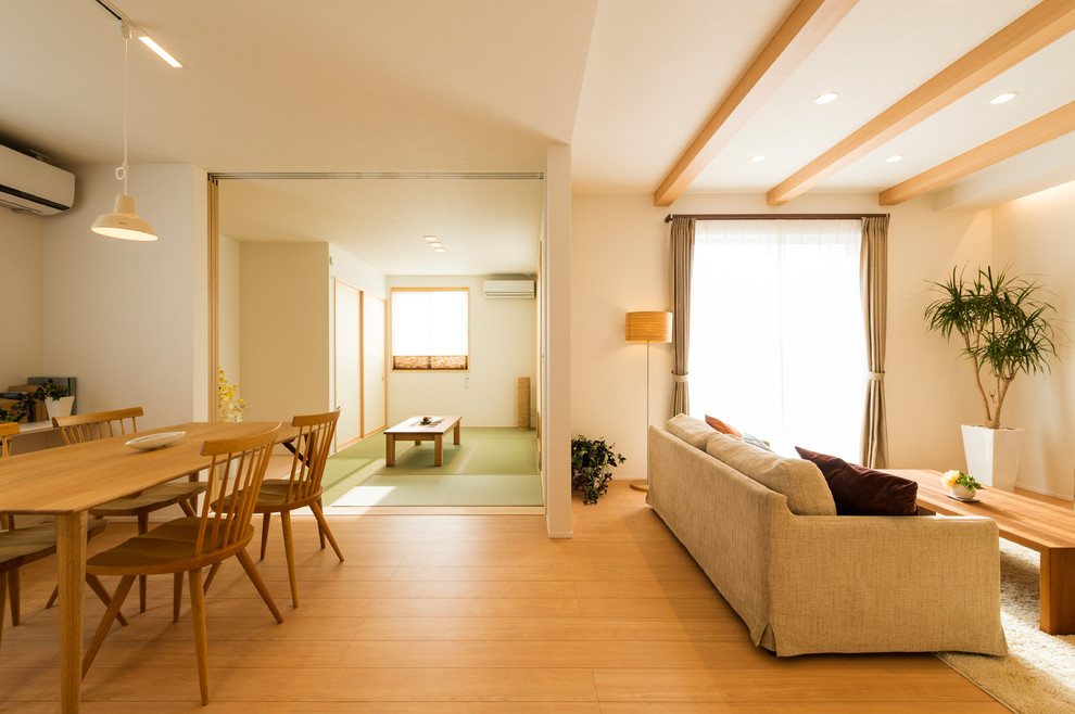 Immagine di un soggiorno scandinavo aperto con pareti bianche, parquet chiaro e pavimento marrone