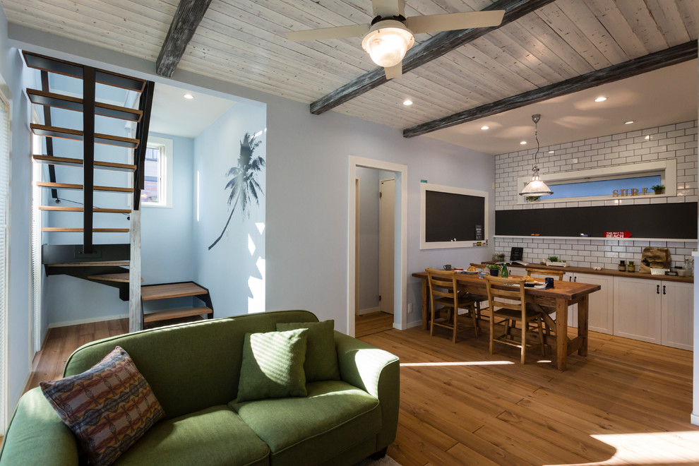 Esempio di un soggiorno costiero aperto con pareti blu, pavimento in legno massello medio e pavimento marrone