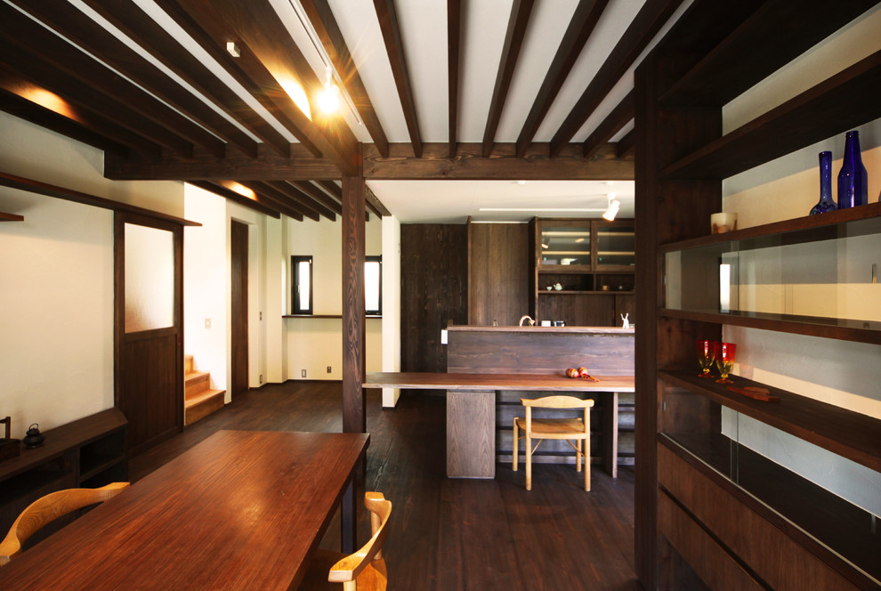Imagen de salón abierto asiático con paredes beige, televisor independiente, suelo marrón y suelo de madera oscura