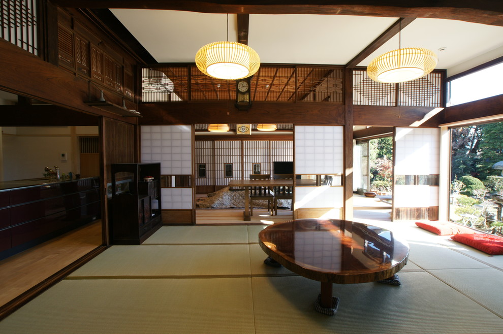 Exemple d'un salon asiatique ouvert avec un mur blanc et un sol beige.