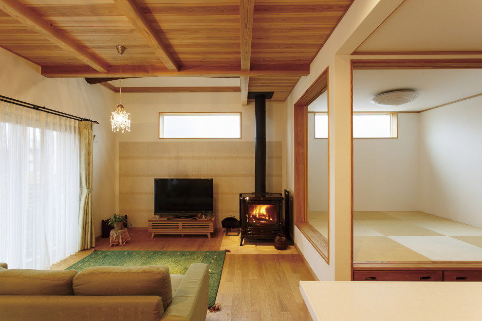 Immagine di un soggiorno design di medie dimensioni e aperto con stufa a legna, cornice del camino piastrellata e pavimento marrone