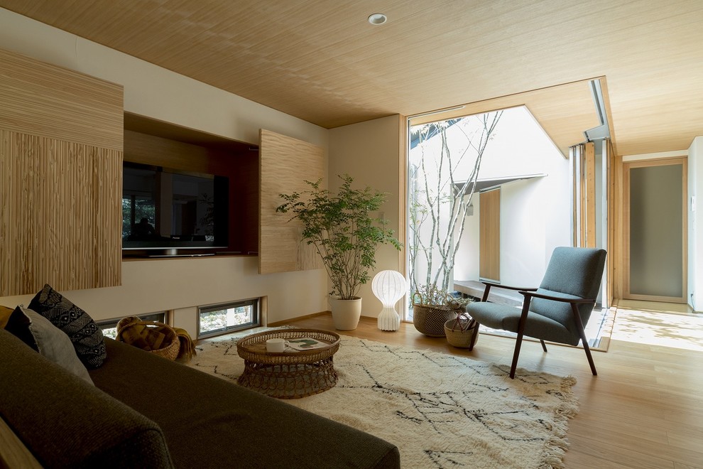 Diseño de salón de estilo zen sin chimenea con paredes blancas y televisor retractable
