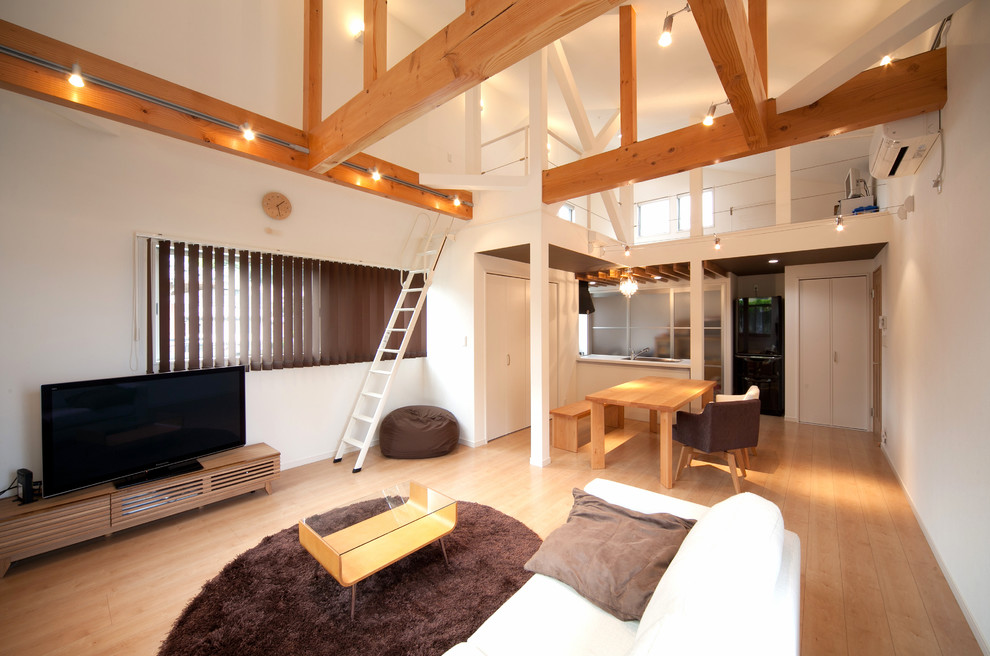 Esempio di un soggiorno etnico con pareti bianche e pavimento in legno massello medio