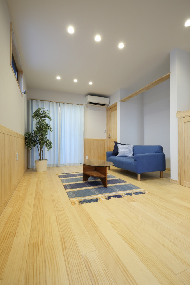 Пример оригинального дизайна: открытая гостиная комната в скандинавском стиле с паркетным полом среднего тона, бежевым полом и деревянными стенами