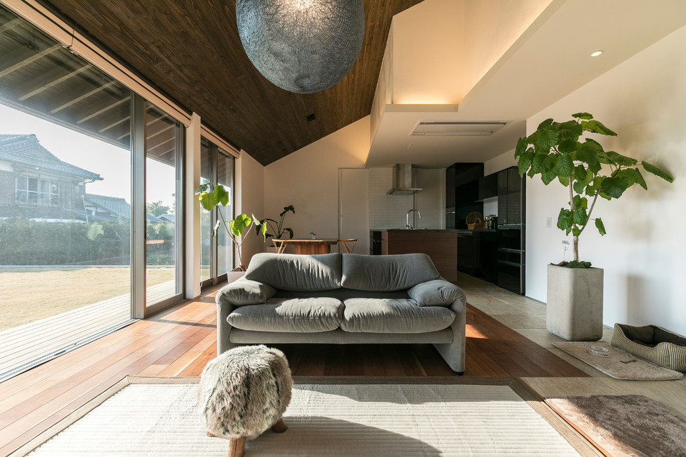 Offenes Asiatisches Wohnzimmer mit weißer Wandfarbe, braunem Holzboden und braunem Boden in Fukuoka