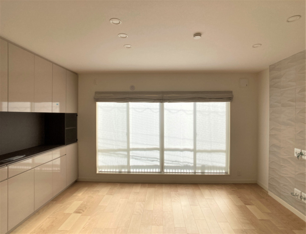 Стильный дизайн: гостиная комната в стиле модернизм с бежевыми стенами, полом из фанеры, телевизором на стене, бежевым полом, потолком с обоями и обоями на стенах без камина - последний тренд