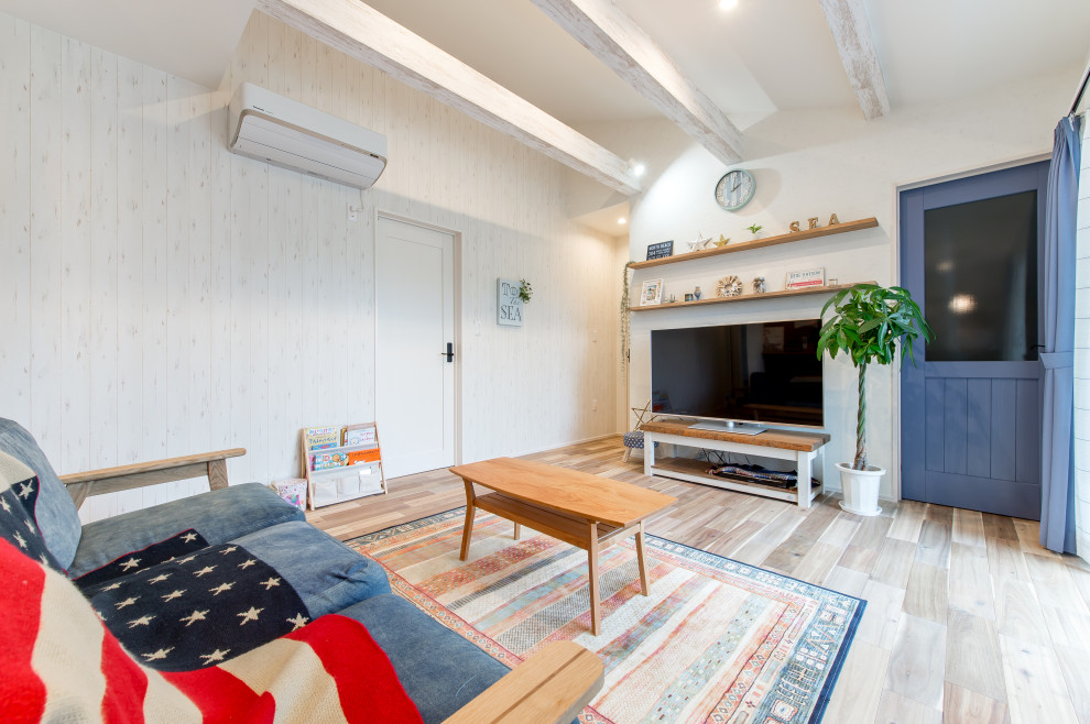Kleines, Offenes Wohnzimmer mit braunem Holzboden, Tapetendecke und Tapetenwänden in Sonstige