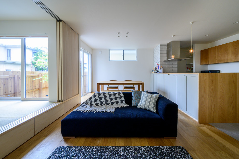 Danish open concept medium tone wood floor and brown floor living room photo in Kobe