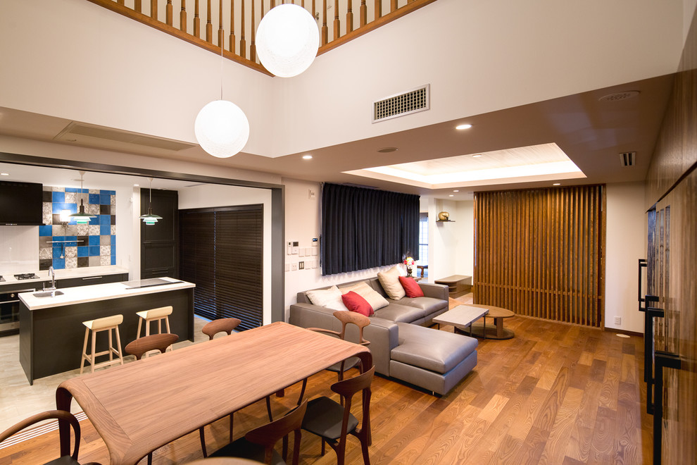 Immagine di un soggiorno minimalista aperto con pareti bianche, pavimento in legno massello medio e pavimento marrone