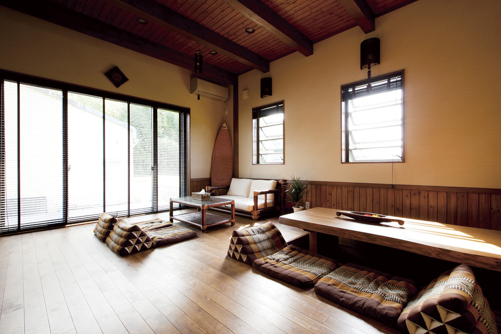 На фото: гостиная комната в восточном стиле с бежевыми стенами, паркетным полом среднего тона и коричневым полом с