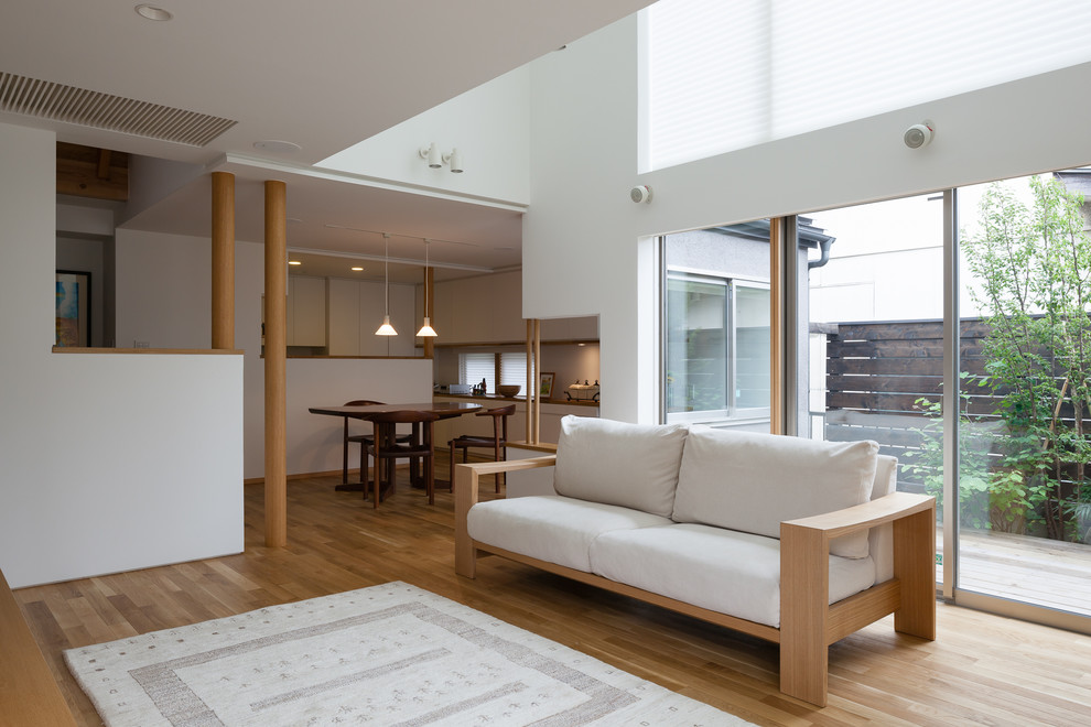 Asiatisches Wohnzimmer mit weißer Wandfarbe, braunem Holzboden und braunem Boden in Tokio