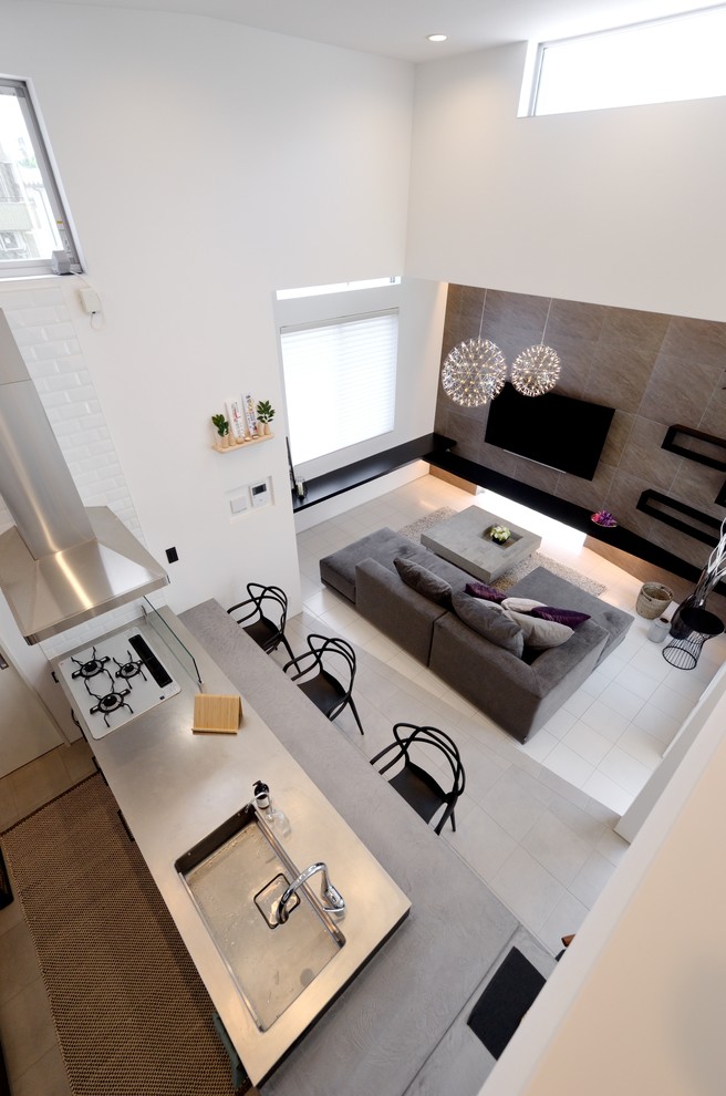 Esempio di un soggiorno moderno aperto con sala formale, pareti bianche, pavimento in marmo, TV a parete e pavimento bianco