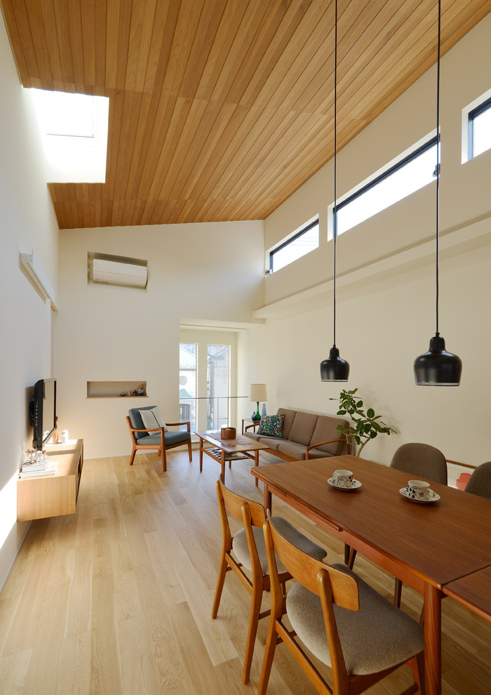 Immagine di un soggiorno scandinavo aperto con pareti bianche, parquet chiaro e pavimento beige