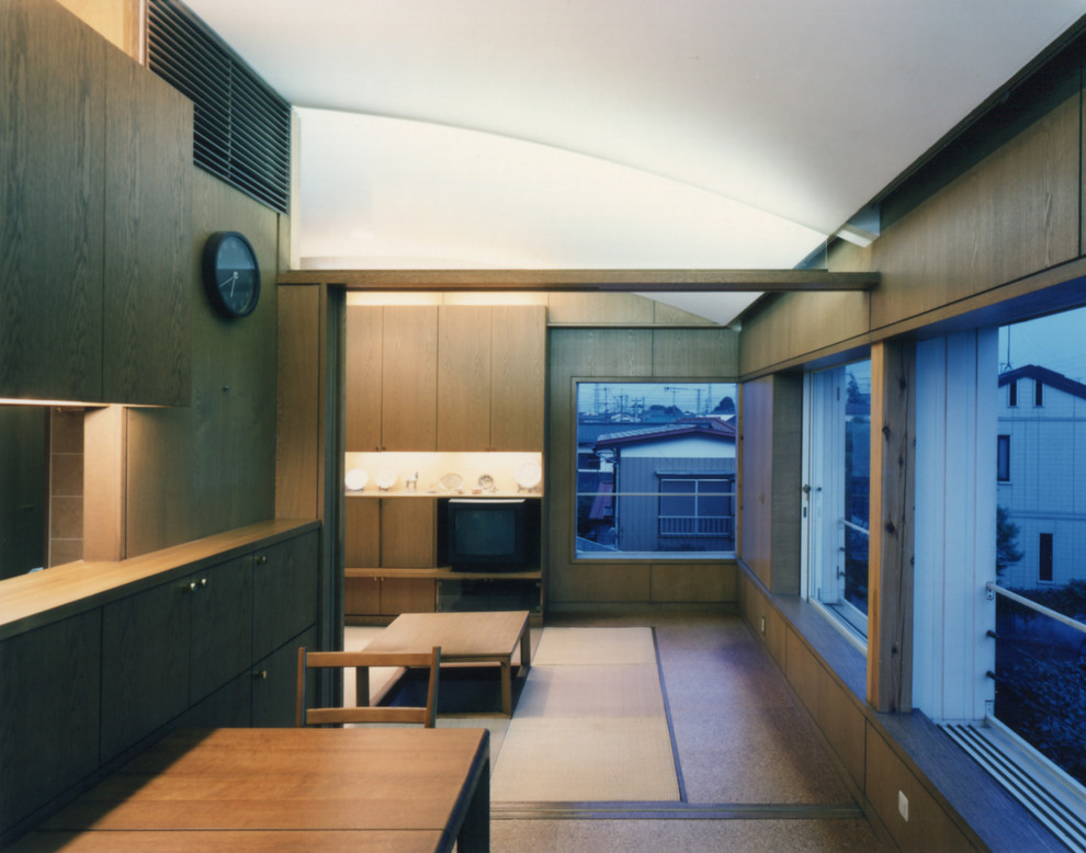 На фото: открытая гостиная комната среднего размера в восточном стиле с коричневыми стенами, пробковым полом, отдельно стоящим телевизором и коричневым полом без камина с