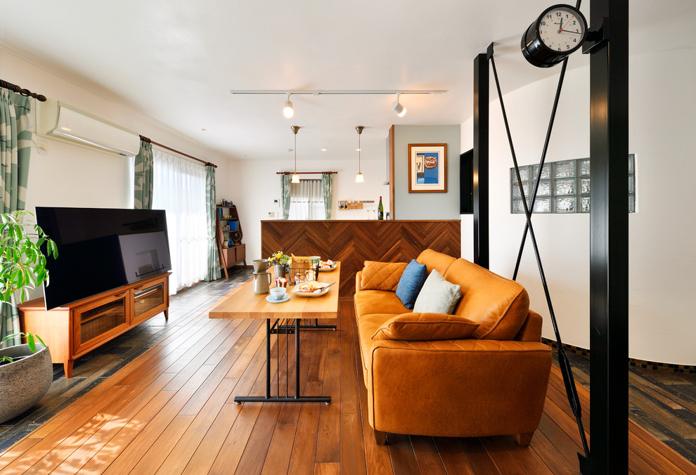 Immagine di un soggiorno scandinavo aperto con pareti marroni, parquet scuro, nessun camino, TV autoportante e pavimento marrone