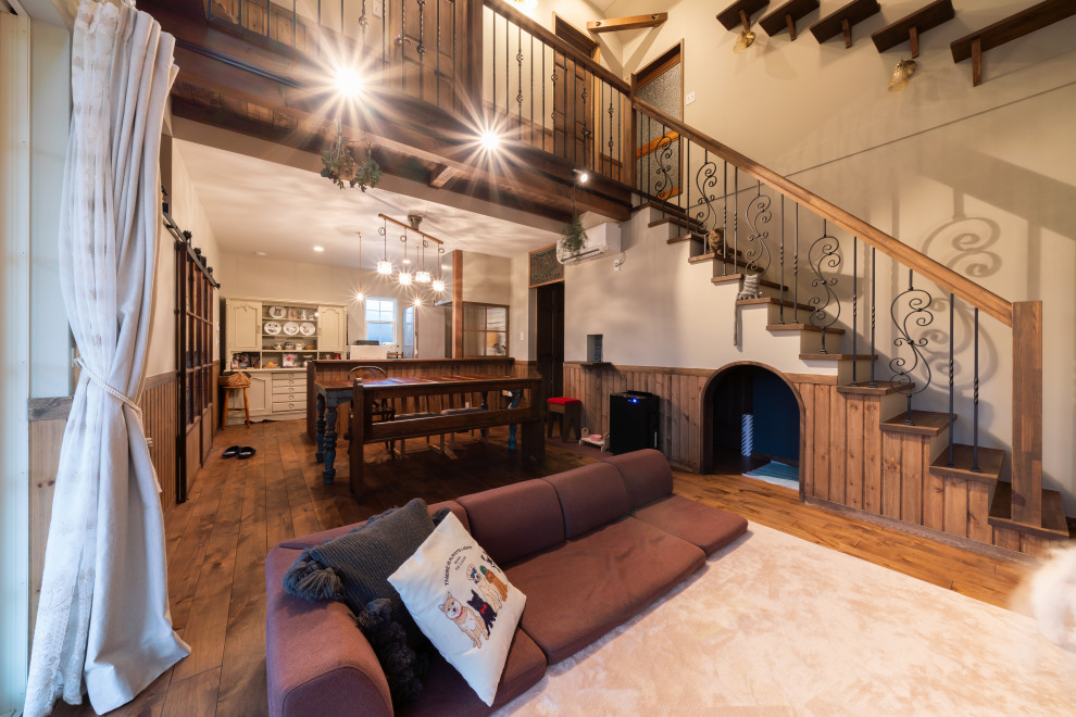 Offenes Klassisches Wohnzimmer mit beiger Wandfarbe, dunklem Holzboden und braunem Boden in Sonstige