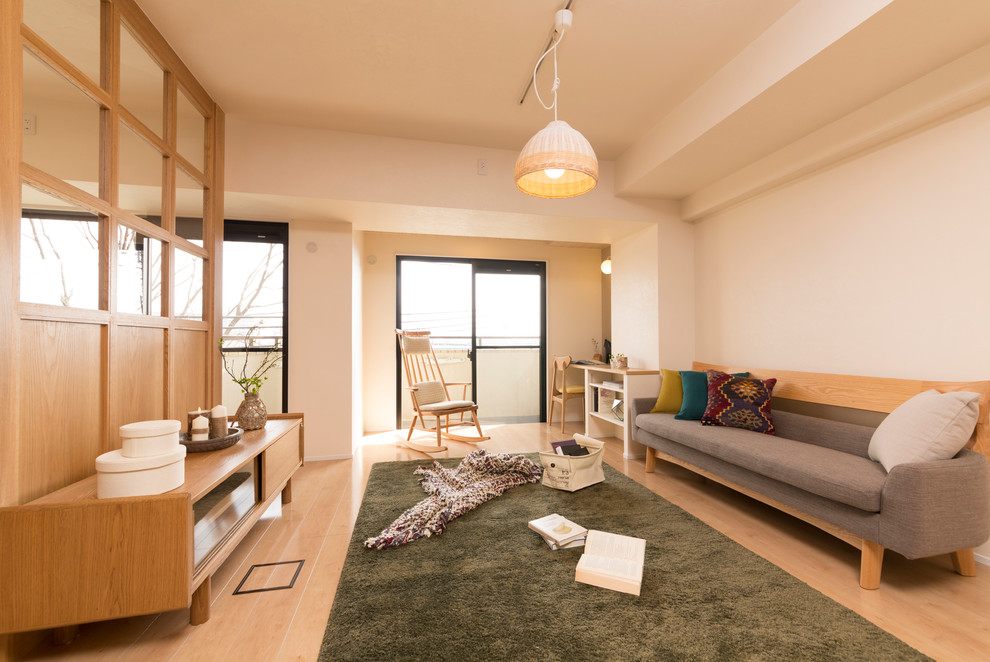 Offenes Skandinavisches Wohnzimmer mit weißer Wandfarbe und Sperrholzboden in Kobe