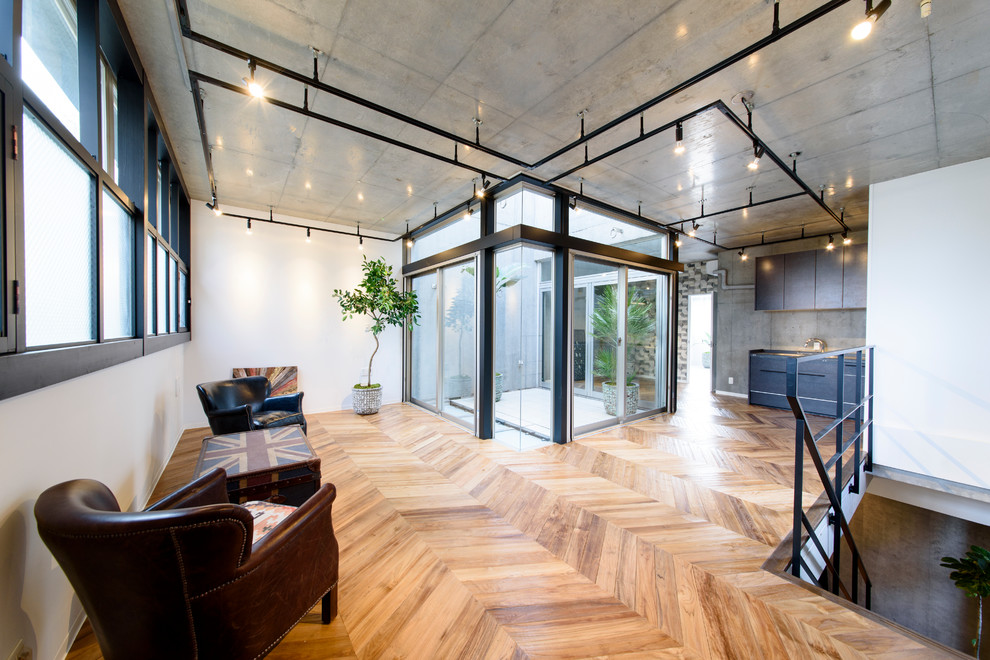 Ispirazione per un soggiorno industriale con pareti bianche, pavimento in legno massello medio e pavimento marrone