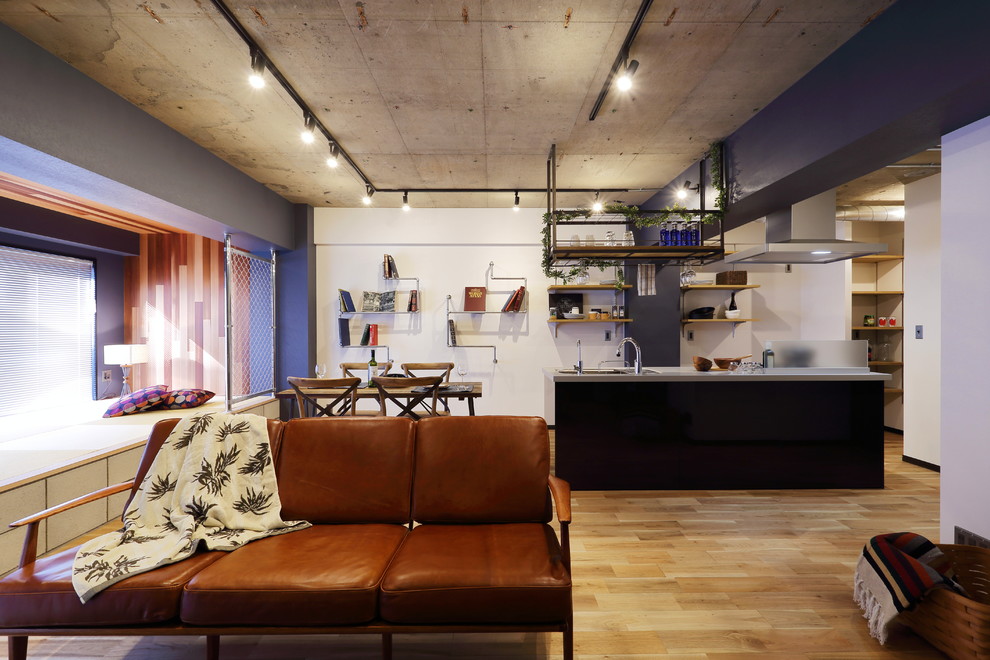 Idée de décoration pour un grand salon urbain ouvert avec un sol en bois brun et un mur multicolore.