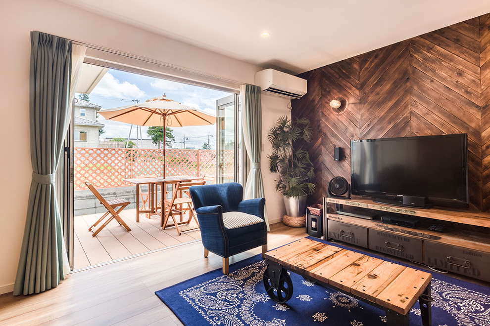 Immagine di un soggiorno costiero con pareti bianche, parquet chiaro, TV autoportante e pavimento marrone