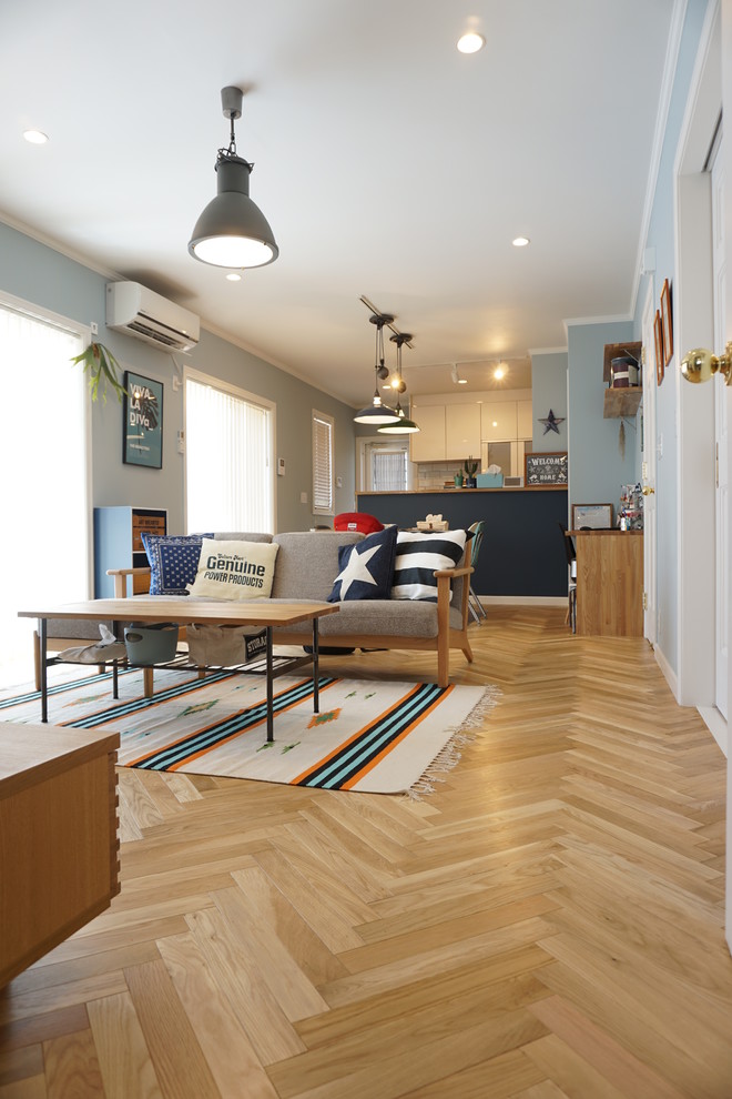 Idéer för ett maritimt vardagsrum, med blå väggar och ljust trägolv