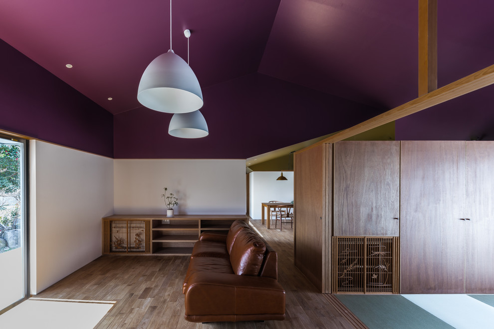 Geräumiges, Offenes Modernes Wohnzimmer ohne Kamin mit weißer Wandfarbe, braunem Holzboden und braunem Boden in Sonstige