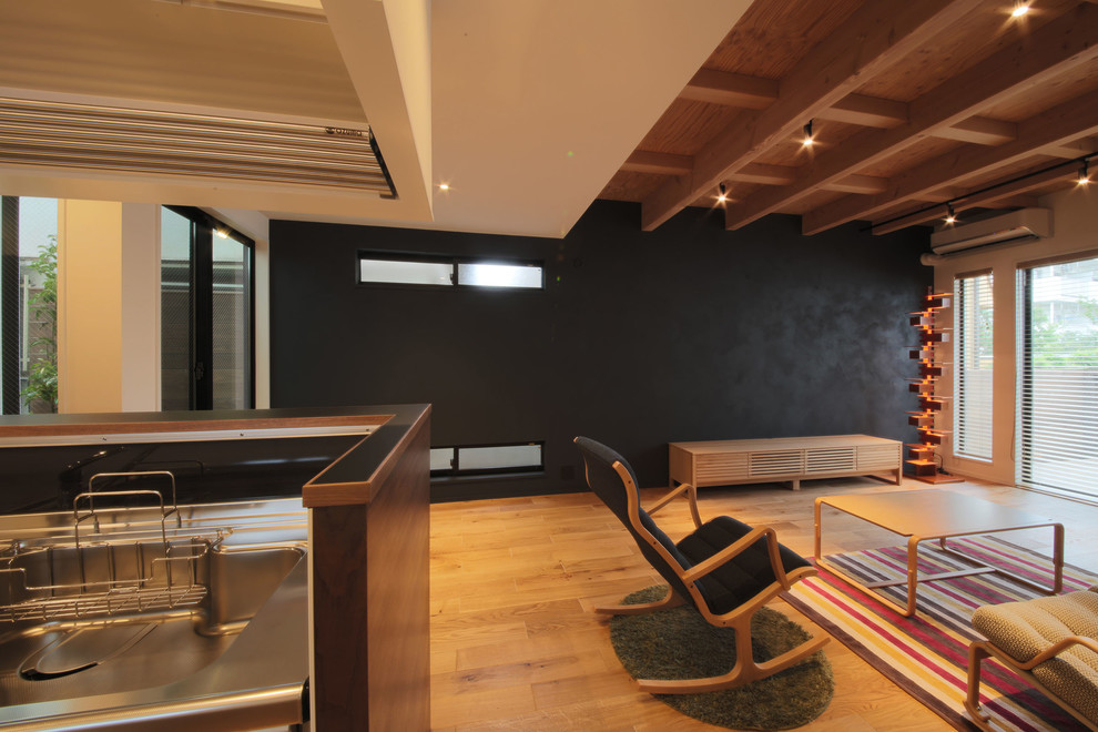 Kleines Modernes Wohnzimmer ohne Kamin mit schwarzer Wandfarbe, freistehendem TV, Sperrholzboden und braunem Boden in Tokio