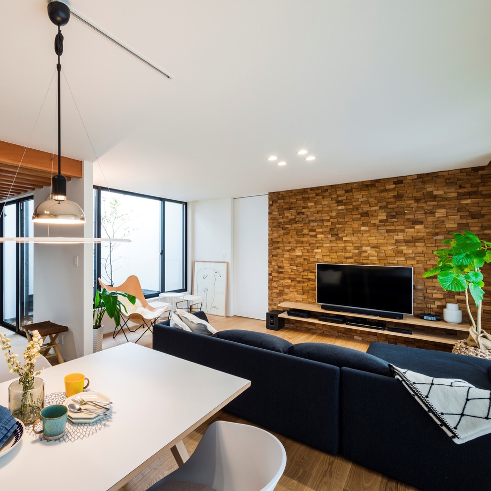 Стильный дизайн: гостиная комната в стиле модернизм с белыми стенами, светлым паркетным полом, отдельно стоящим телевизором и коричневым полом - последний тренд