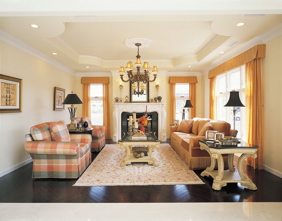 Klassisches Wohnzimmer mit gelber Wandfarbe, dunklem Holzboden und braunem Boden in Sonstige