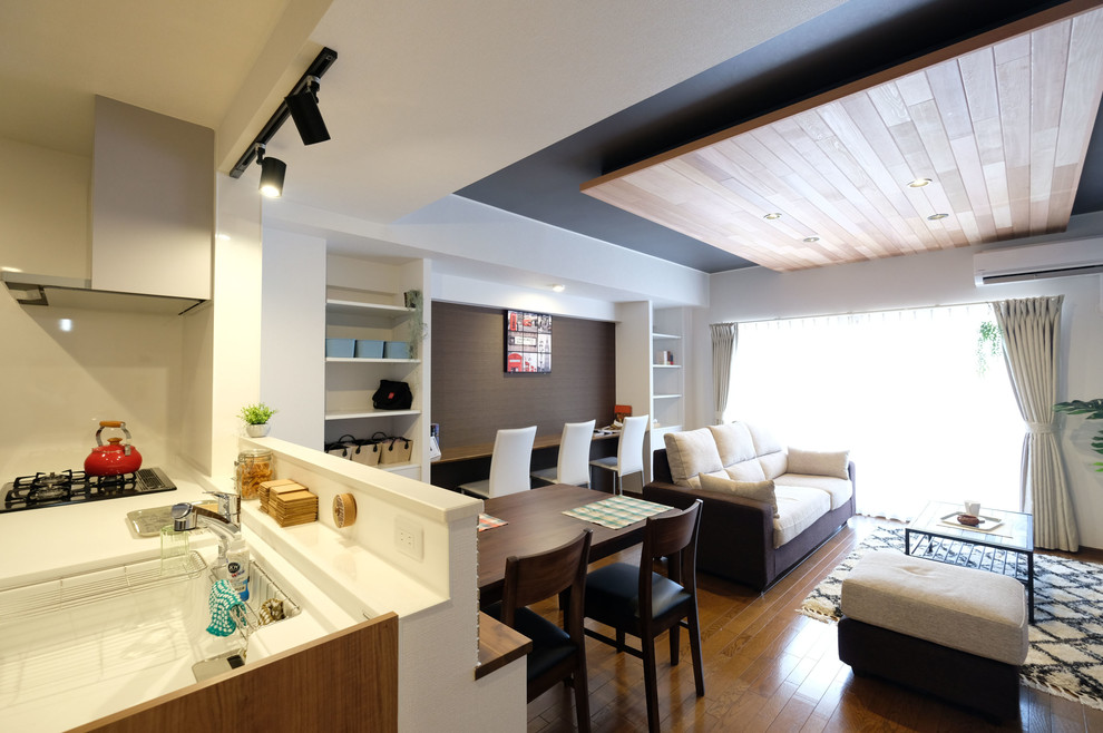 На фото: большая парадная, открытая гостиная комната в стиле модернизм с белыми стенами, полом из фанеры, отдельно стоящим телевизором и коричневым полом без камина