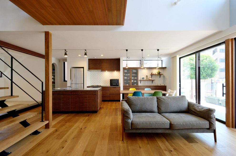 World-inspired open plan living room in Tokyo Suburbs with white walls, medium hardwood flooring and brown floors.