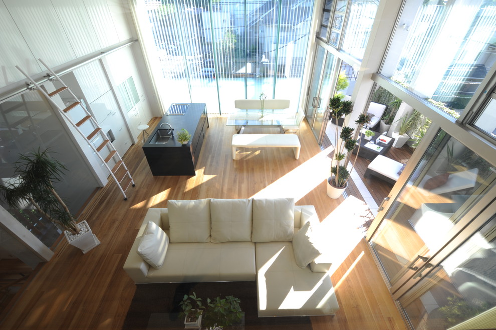 Ispirazione per un grande soggiorno minimalista aperto con sala formale, pareti bianche, pavimento in legno massello medio e nessun camino