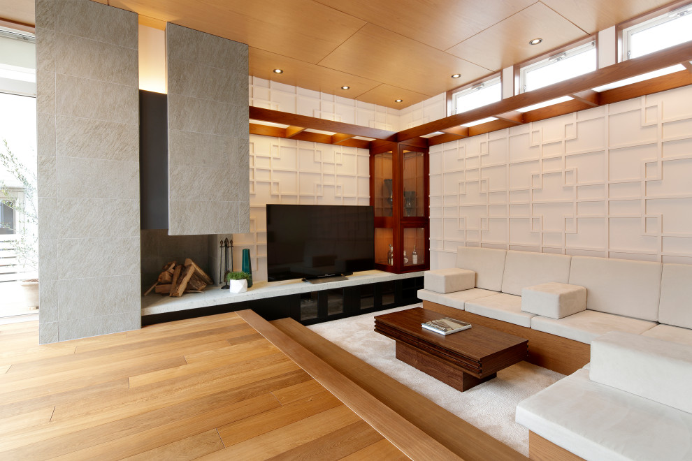 Idee per un soggiorno etnico aperto con pareti bianche, pavimento in legno massello medio, camino classico, TV autoportante e pavimento marrone