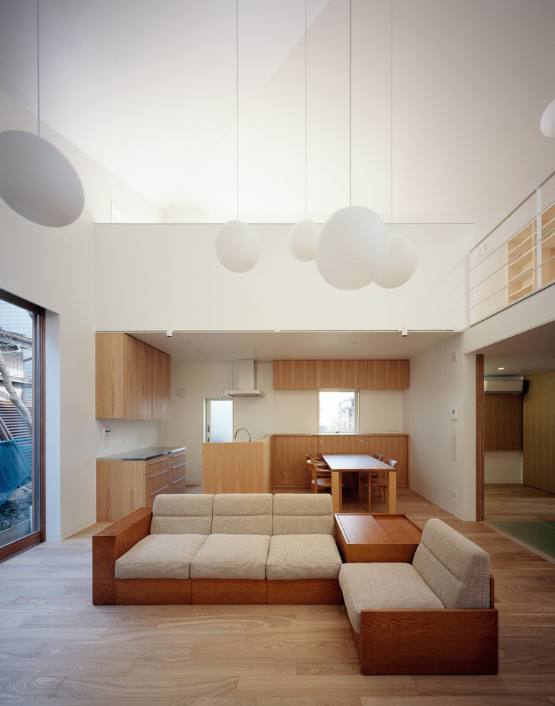 Inspiration för mellanstora moderna allrum med öppen planlösning, med vita väggar, ljust trägolv och en fristående TV