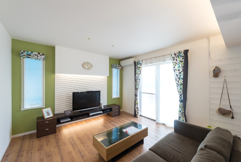 Foto di un soggiorno minimalista di medie dimensioni e chiuso con pareti multicolore, pavimento in compensato, TV autoportante e pavimento marrone