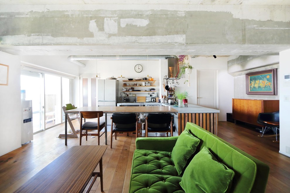 Rustic open plan living room in Tokyo with white walls, medium hardwood flooring and brown floors.