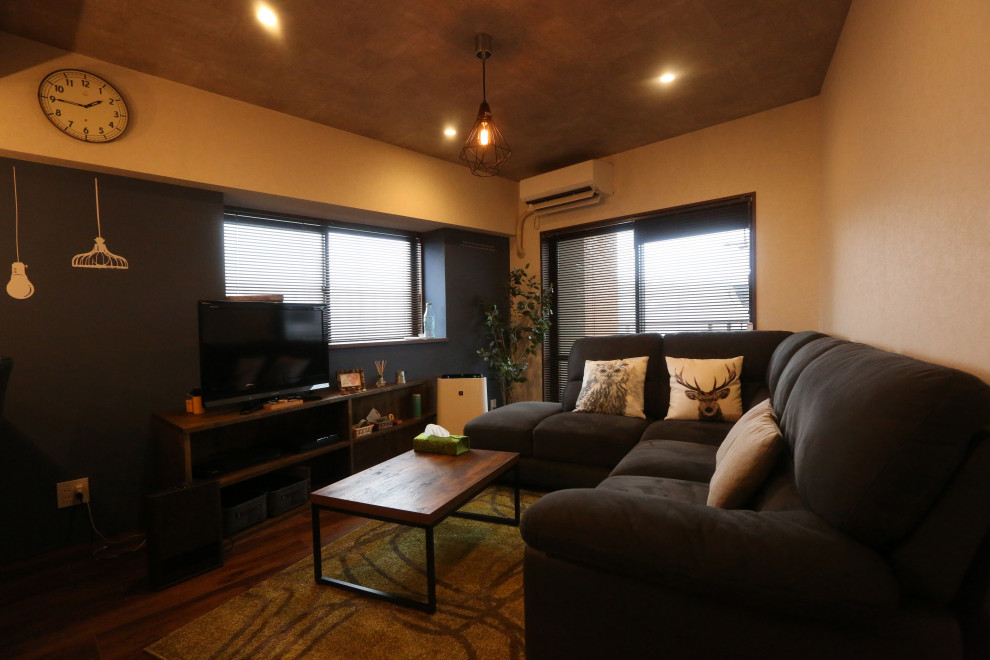 Modelo de salón para visitas abierto de tamaño medio con paredes negras, suelo de madera oscura, televisor independiente, suelo marrón y papel pintado
