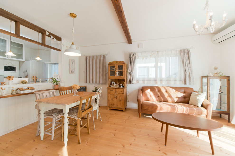 Offenes Landhaus Wohnzimmer ohne Kamin mit weißer Wandfarbe, hellem Holzboden, beigem Boden und freistehendem TV in Sonstige