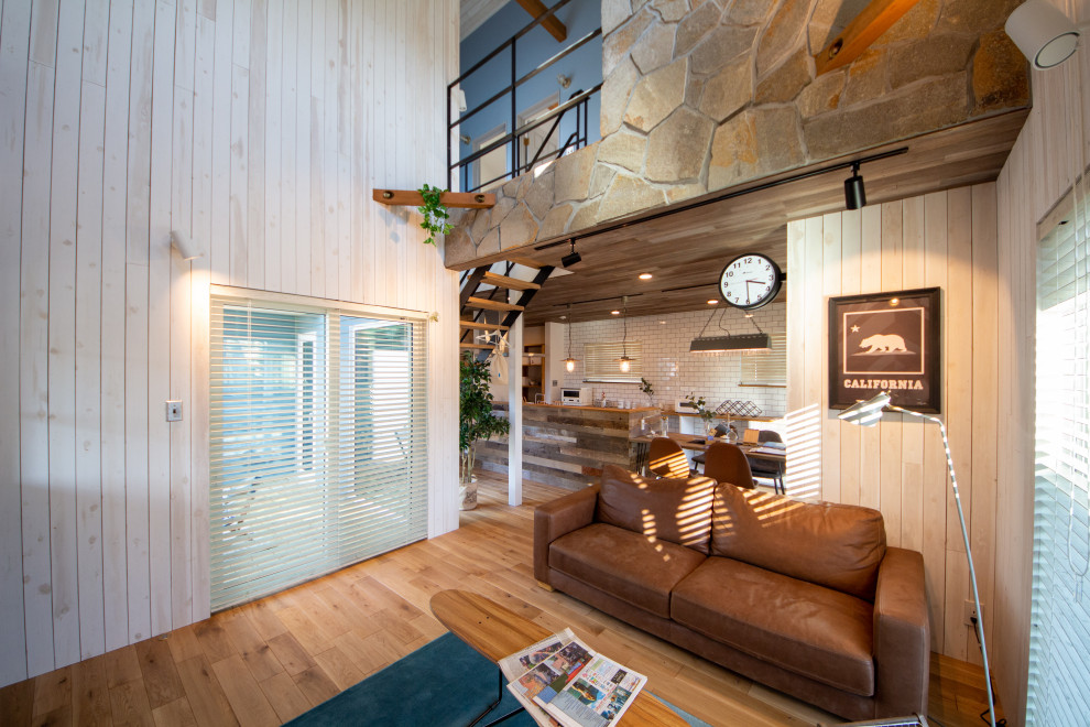 Стильный дизайн: гостиная комната в морском стиле с с книжными шкафами и полками, белыми стенами, паркетным полом среднего тона и коричневым полом - последний тренд