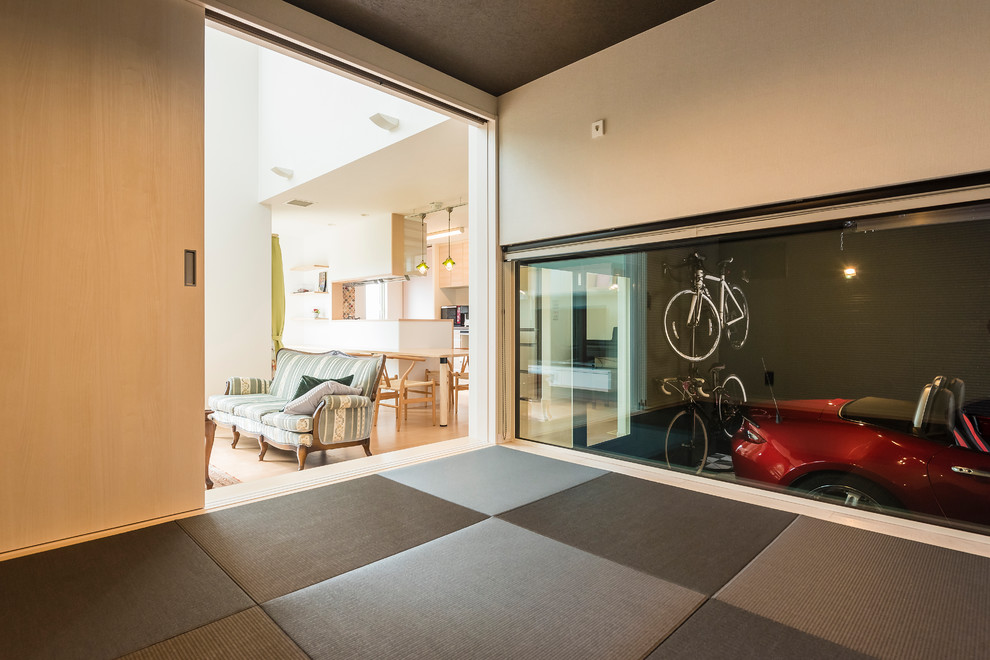 Idee per un soggiorno minimalista con pareti bianche, pavimento in tatami e pavimento nero