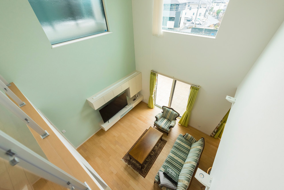 Immagine di un soggiorno minimalista con pareti verdi, nessun camino e pavimento beige