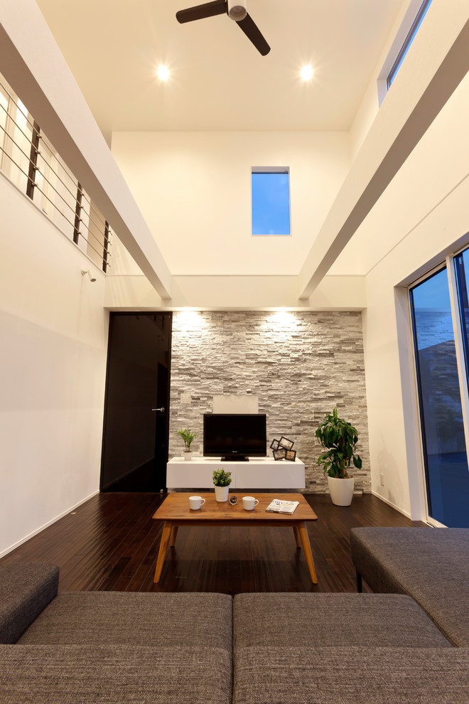 Diseño de salón contemporáneo con paredes blancas, suelo de madera oscura, televisor independiente y suelo marrón