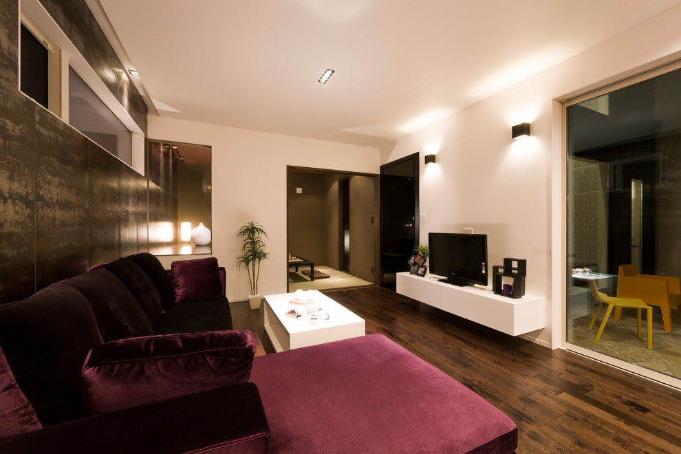 Inspiration pour un salon minimaliste avec un mur blanc, parquet foncé, un téléviseur indépendant et un sol marron.