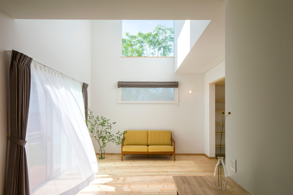 Idéer för ett minimalistiskt allrum med öppen planlösning, med vita väggar, ljust trägolv och brunt golv