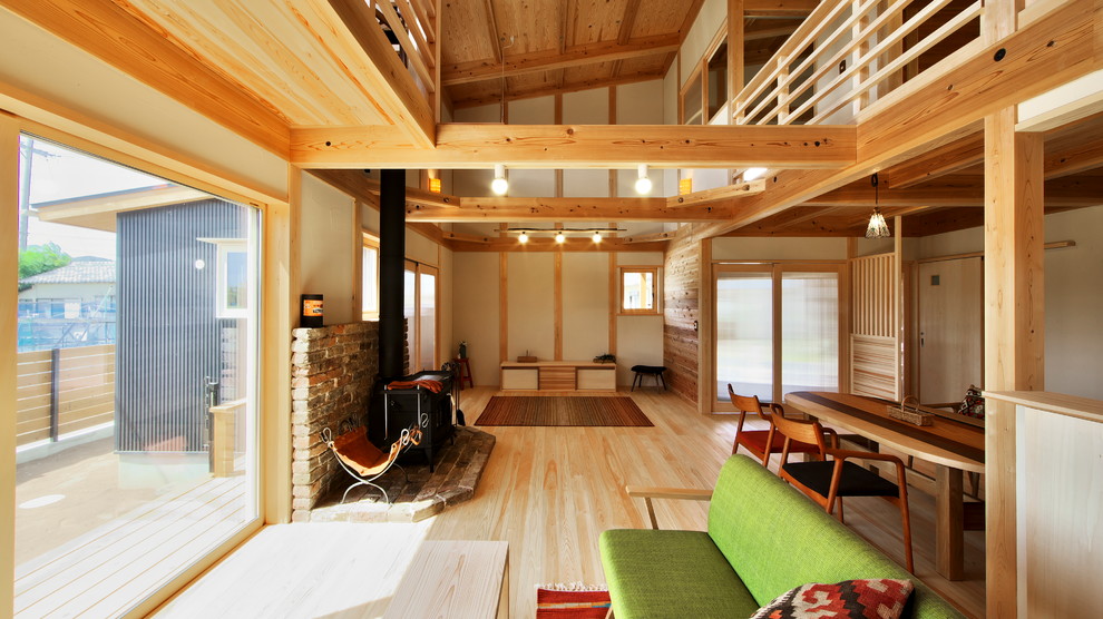 Fernseherloses, Offenes Rustikales Wohnzimmer mit beiger Wandfarbe, hellem Holzboden, Tunnelkamin und Kaminumrandung aus Backstein in Tokio