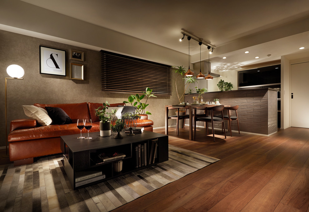 Offenes Modernes Wohnzimmer mit grauer Wandfarbe, braunem Holzboden und braunem Boden